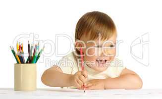 Cute happy child draw with red crayon
