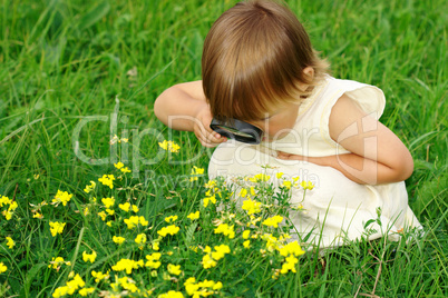 Child looking at flowers through magnifying glass