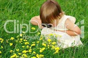 Child looking at flowers through magnifying glass