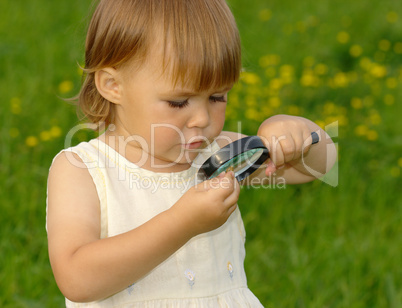 Child looking at snail through magnifying glass