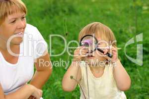 Child looking at flower through magnifying glass