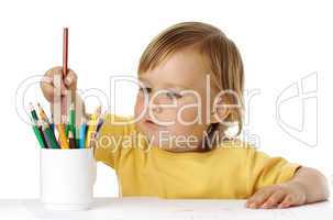 Child picking a crayon from the cup