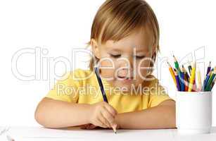 Cute preschooler focused on her drawing