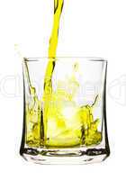 Splash, yellow drink is being poured into glass