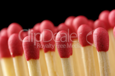 Line of red matchsticks on black background