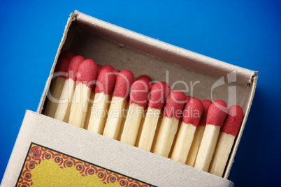 Red matchsticks in the box on blue background