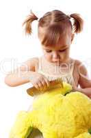 Cute girl combing her soft toy