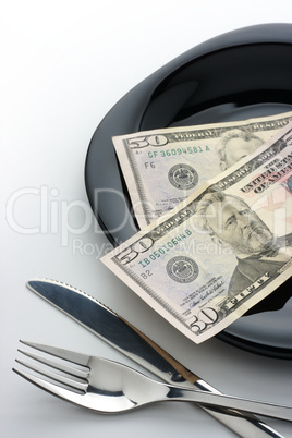 Dollars on plate with fork and knife