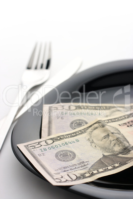 Dollars on plate with fork and knife