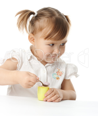 Little girl eats yogurt