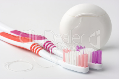 Two toothbrushes and dental floss