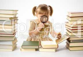 Little girl looking at book through magnifier