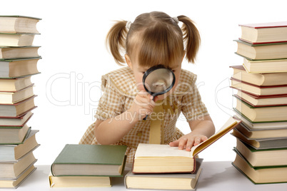 Little girl looking at book through magnifier