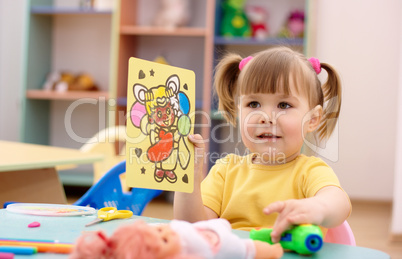 Little girl showing a picture in preschool