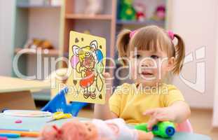 Little girl showing a picture in preschool