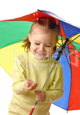Cute child catching raindrops under umbrella