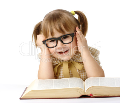 Happy little girl with book wearing black glasses