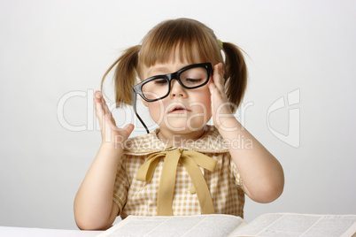 Little girl with books wearing black glasses