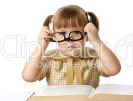 Cute little girl with book wearing black glasses