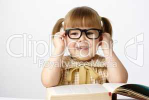 Happy little girl with books wearing black glasses