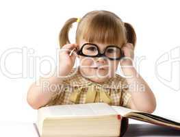 Happy little girl with books wearing black glasses