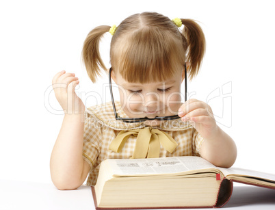 Happy little girl with book wearing black glasses