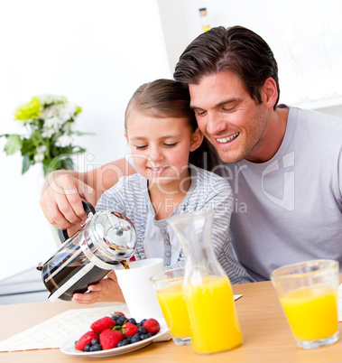Cheerful father and his daughter having breakfast together