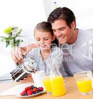Cheerful father and his daughter having breakfast together