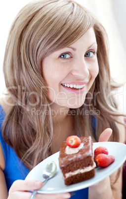Cheerful woman holding a piece of chocolate cake