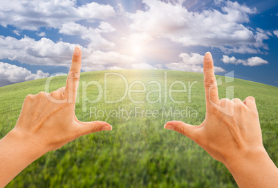 Female Hands Making a Frame Over Grass and Sky
