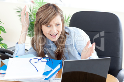 Angry businesswoman looking at the laptop