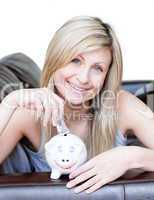 Delighted woman using a piggybank
