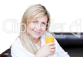 Delighted woman drinking an orange jus