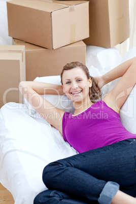 Portrait of a cute woman relaxing on a sofa with boxes