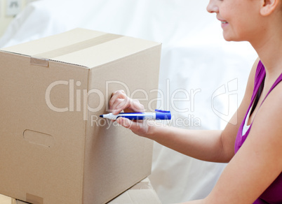 Caucasian woman writing on a box