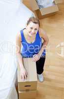 Positive woman is moving various boxes
