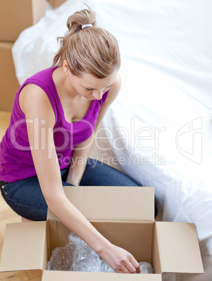 Radiant woman unpacking box