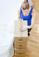 Caucasian woman is moving various boxes