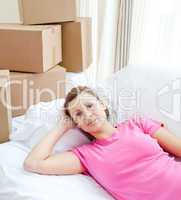 Pensive woman relaxing on a sofa with boxes