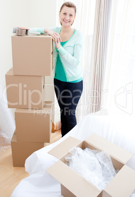 Smiling woman closing various boxes