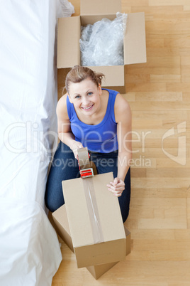 Smiling woman closing a box