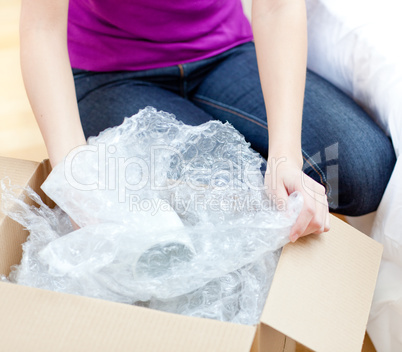 Young woman unpacking box