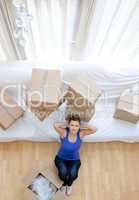 Exhausted woman sitting between boxes at home