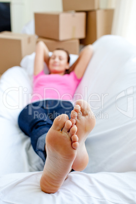 Cheerful woman relaxing on a sofa with boxes