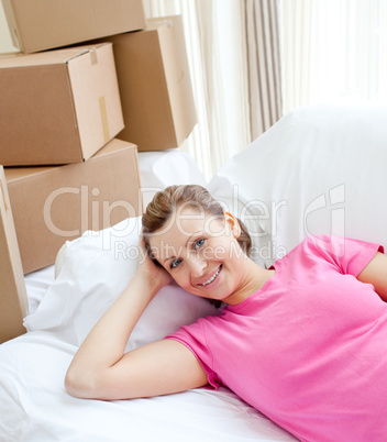 Happy woman relaxing on a sofa with boxes