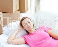 Sleeping woman relaxing on a sofa with boxes