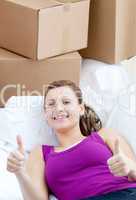 Portrait of a radiant woman relaxing on a sofa with boxes