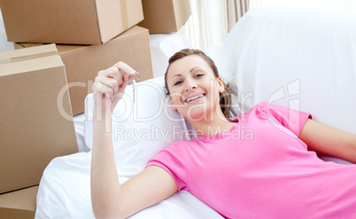 Self-assured woman relaxing on a sofa with boxes