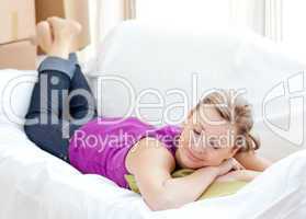 Portrait of a cheerful woman relaxing on a sofa with boxes