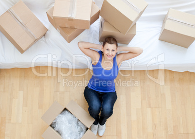 Beautiful woman sitting between boxes at home